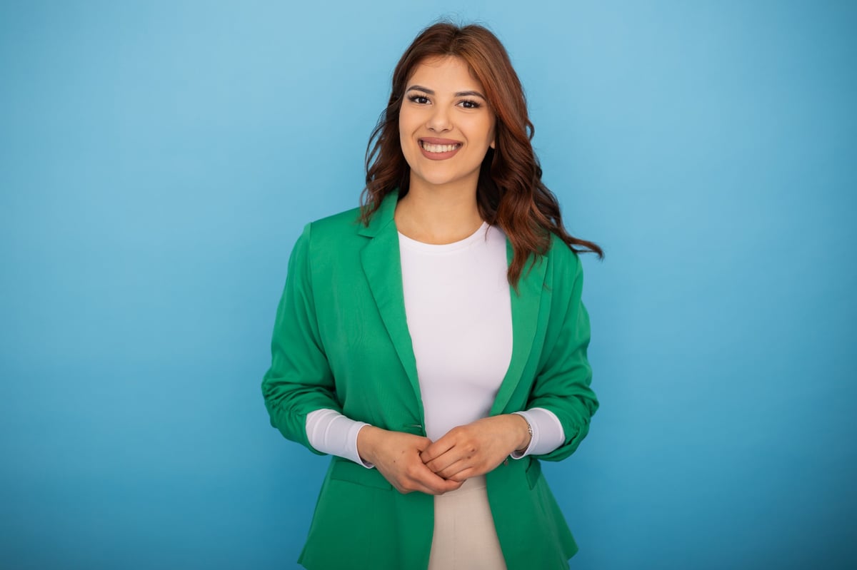 Portrait of a confident businesswoman wearing a stylish green jacket, smiling brightly